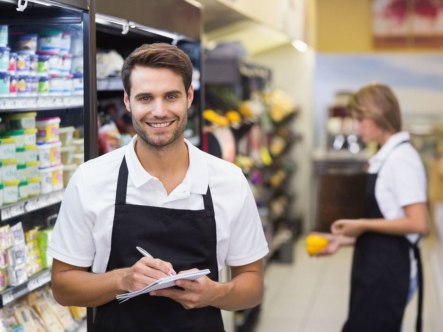 Personal de tienda con delantal atendiendo en el supermercado