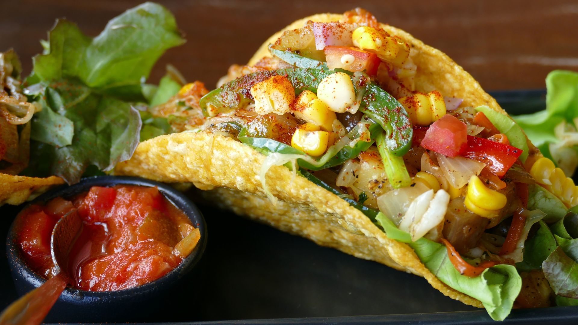 Tacos mexicanos recién preparados con salsa fresca y verduras