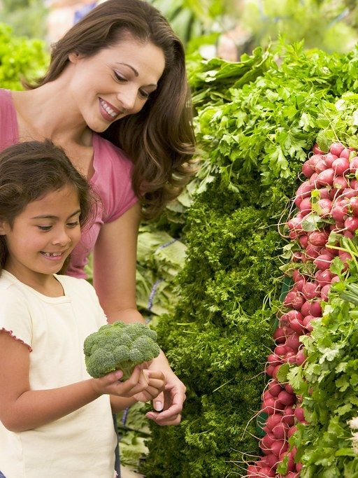 Madre e hija eligiendo fruta fresca en el supermercado